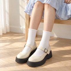 AI-assisted seated outfit image of white fine-rib roll-top socks with a light blue skirt