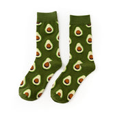 Pair of Green Avocado crew socks with avocado halves on a green background
