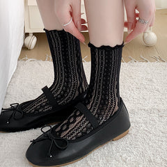 Black cable-pattern mesh crew socks with ruffled cuffs, worn with black Mary Jane flats