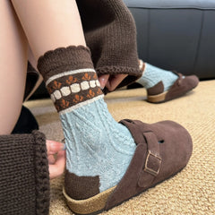 Blue style socks with a pale blue cable-like body and contrasting brown patterned cuffs
