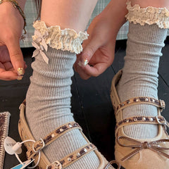 Gray ribbed crew socks with cream crochet-look ruffle cuffs and stacked bows, worn with separate styling shoes