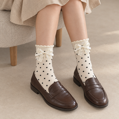 AI styling illustration of white black-dot layered lace-bow socks with brown loafers beside an oatmeal stool
