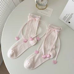 Pink diamond knit crew socks with scalloped tops, ribbon bows and heart-shaped ribbon ends.
