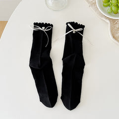Black floral crew socks with tonal flower outlines and dotted ribbon cuff bows