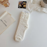 White textured crew socks with stacked cuff folds and two white ribbon bows