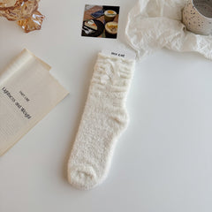 White textured crew socks with stacked cuff folds and two white ribbon bows