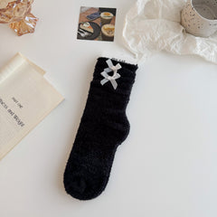 Black textured crew socks with folded cuffs and two contrasting white bows