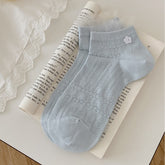 Blue ankle socks with leaf-like eyelet motifs, white flower-button detail and fine mesh frills