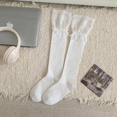 White long socks laid flat with broad gathered floral lace cuffs and plain bodies