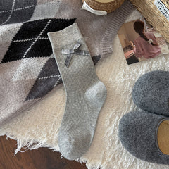 Light Gray ribbed crew sock with a gray gingham bow below the cuff, shown flat beside styling props