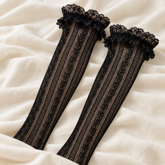AI diagonal product illustration of two long Black heart-link mesh shafts on pale fabric, with foot ends hidden by the cloth edge.