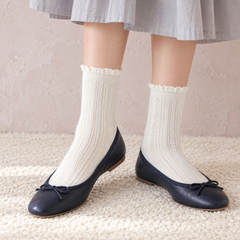 AI styling illustration of White fine-pointelle socks with small curled rims, navy ballet flats and a pale gray skirt