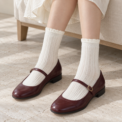 AI high seated-outfit illustration of White fine-pointelle socks with oxblood Mary Janes and an ivory skirt