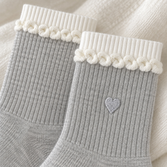 AI close product illustration of the white ribbed upper bands, curled-knit row and pale-gray heart on Light Gray socks.