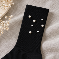 AI close product illustration of a straight Black ribbed cuff and seven scattered white pearl-style beads.