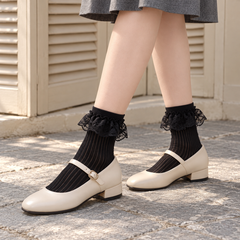 AI editorial illustration of Black semi-sheer ribbed crew socks with single floral lace flounces, cream Mary Janes and a gray skirt by beige shutters.