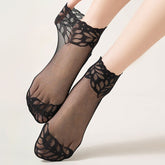 Black sheer ankle socks with pointed leaf-lace cuffs, shown on feet