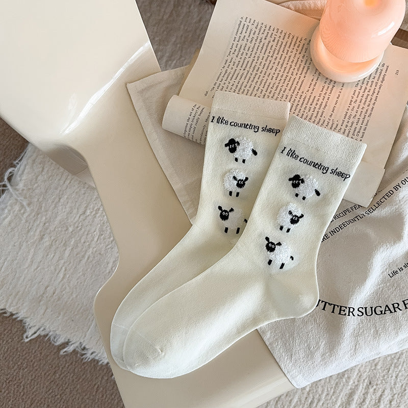 White Lamb crew socks with raised sheep motifs and counting-sheep lettering near the cuffs