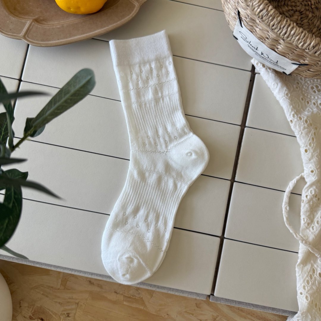 Natural White ribbed sock with straight cuff and horizontal bands of small round eyelets