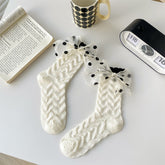 White chevron-textured socks with sheer black-dotted bows at the cuffs