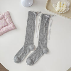 Gray pointelle crew socks with narrow cuff edging and long gray ribbon tails