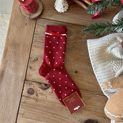 Red crew sock with white polka dots, a red bow and a white stripe below the cuff