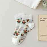 White sheer ankle socks with colorful rose bouquets, white toes and heels, and lightly frilled cuffs