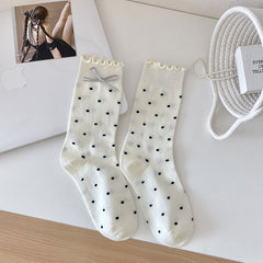 White dotted socks with frilled cuffs and a gray bow shown on one sock