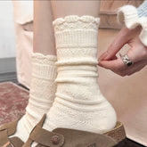 White crew socks with scalloped cuffs and horizontal knit textures, styled with brown shoes