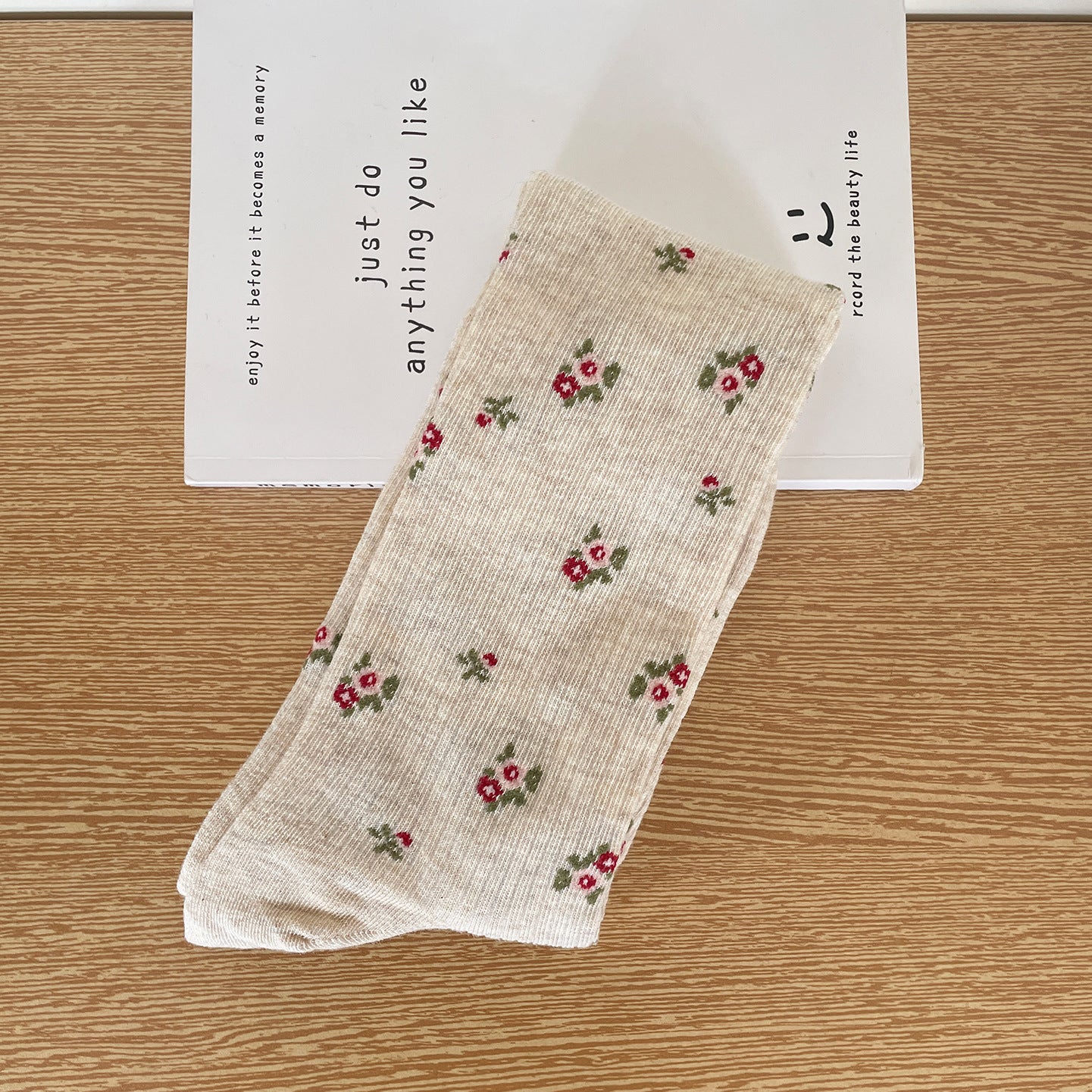 Oatmeal calf sock with fine vertical ribs and scattered pink-and-red flower clusters, laid flat