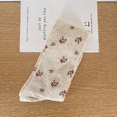 Oatmeal calf sock with fine vertical ribs and scattered pink-and-red flower clusters, laid flat