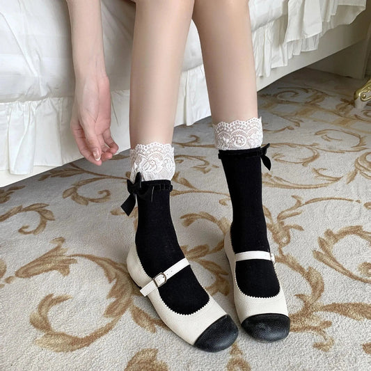 Black socks with white lace cuffs and black bows worn with two-tone strap shoes
