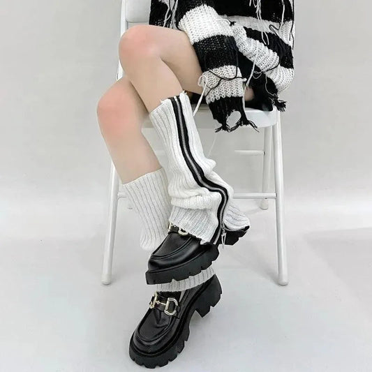 White ribbed leg warmers with black zippers worn over chunky black shoes
