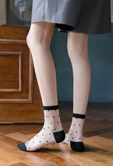 Black polka dot sheer socks worn with a gray skirt