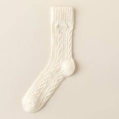 Cream crew sock with twisted cable knit columns, a straight ribbed cuff and a small tonal embroidered bow