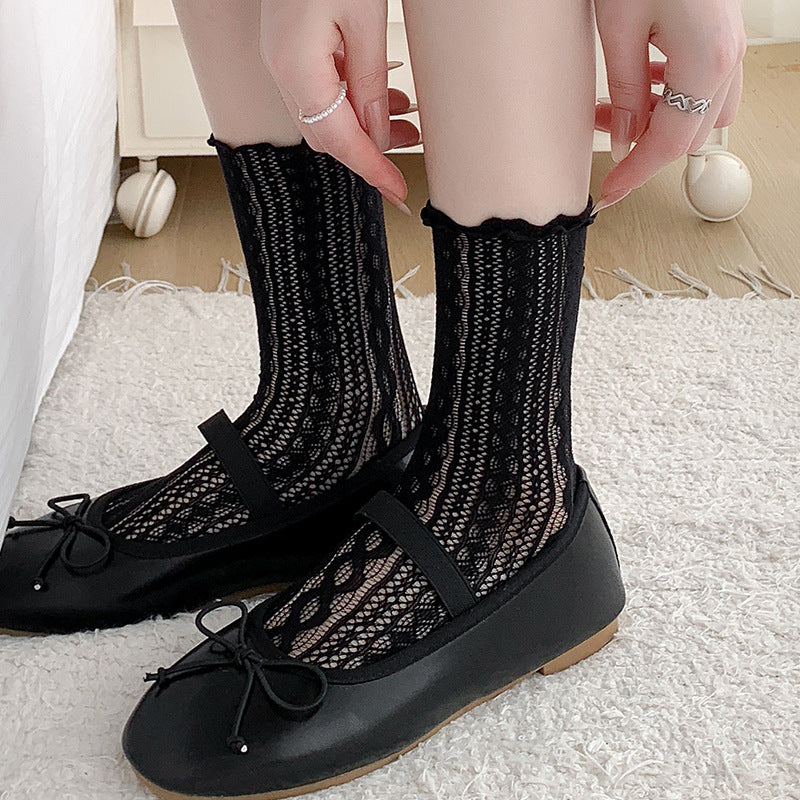 Black cable-pattern mesh crew socks with ruffled cuffs, worn with black Mary Jane flats