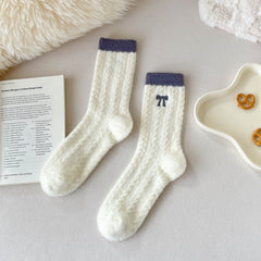 Gray Trim cream crew socks with fuzzy diamond texture, dark cuffs and embroidered bow in a flat lay