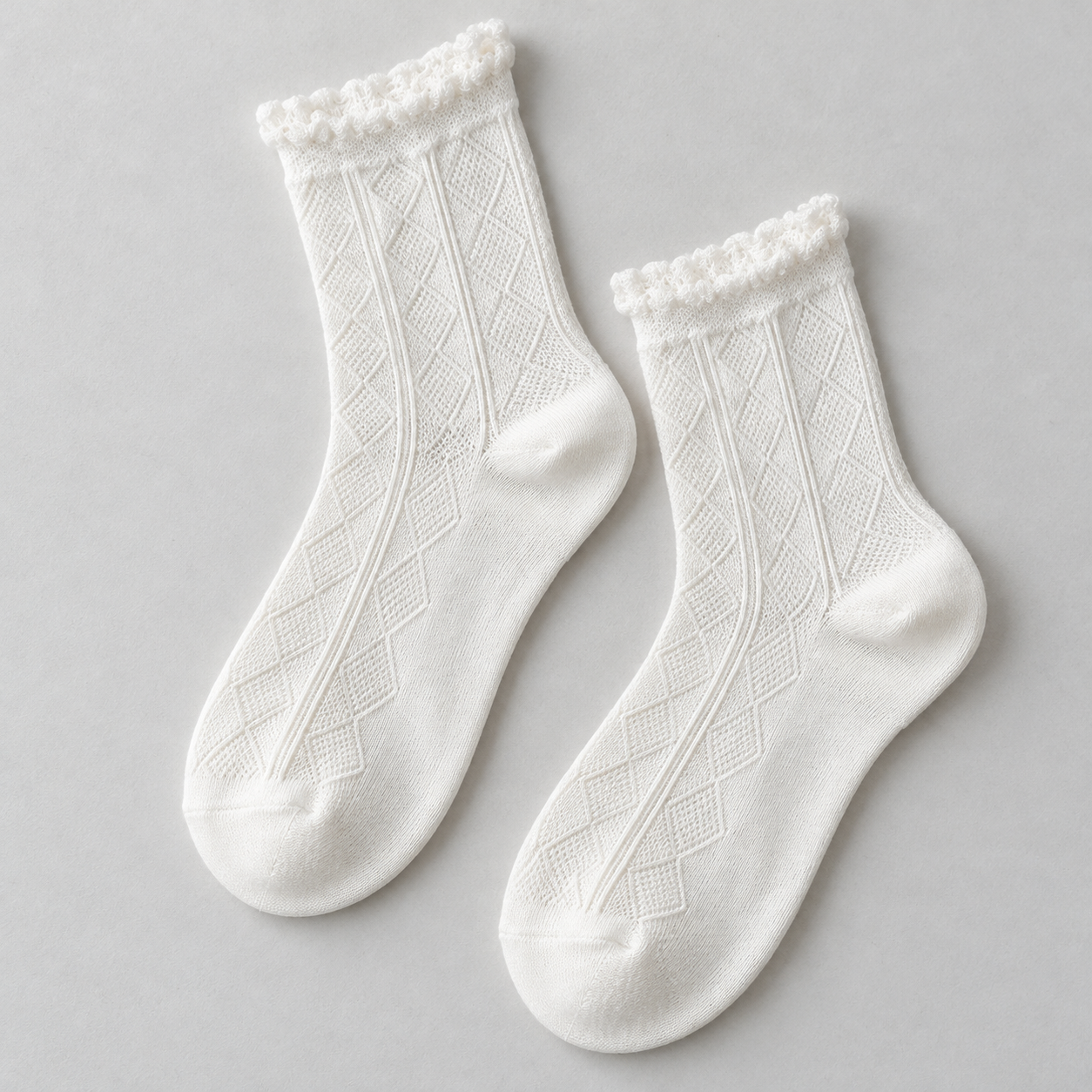 AI product illustration of one White pair with elongated tonal diamond patterns and narrow frilled cuffs on a pale grey surface.