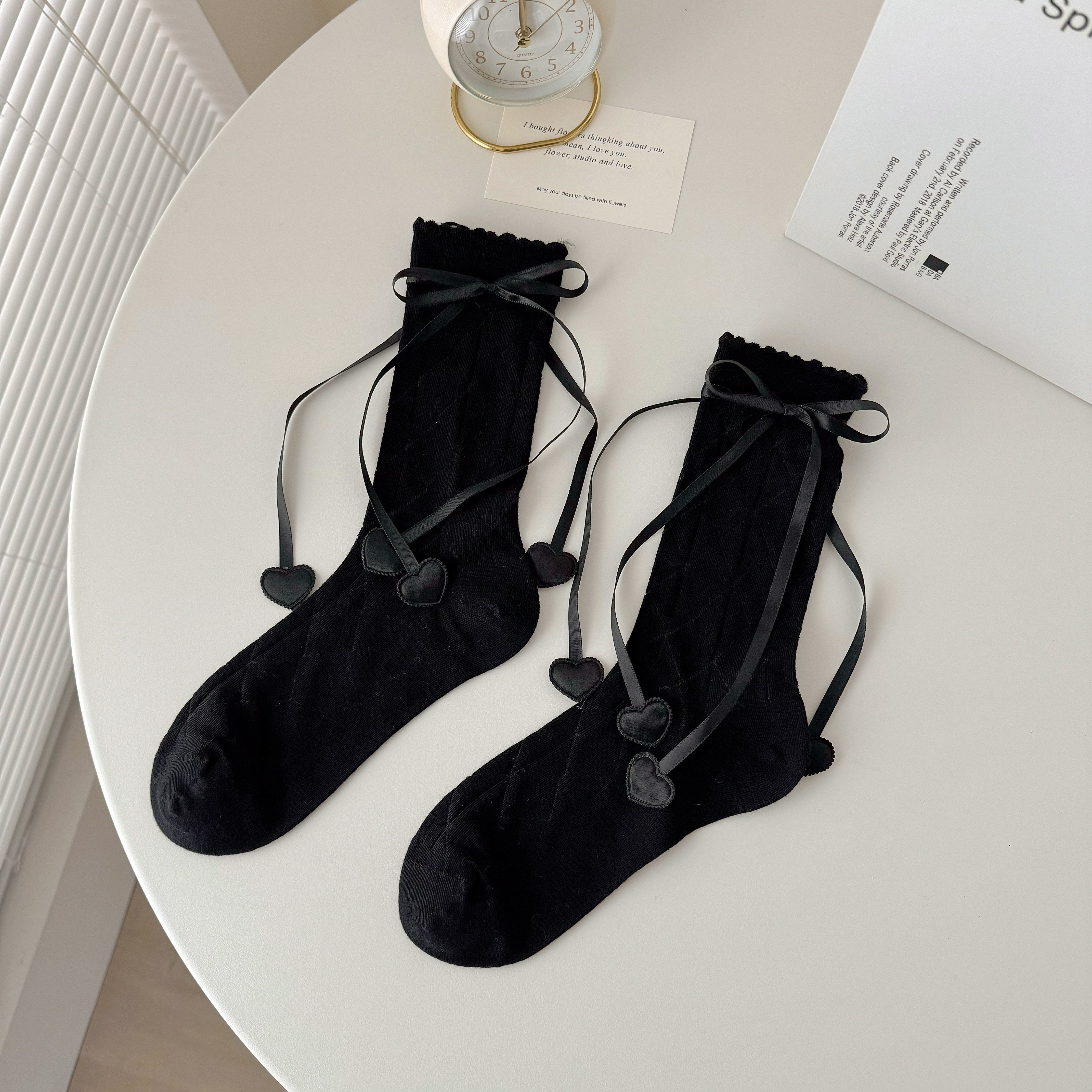 Black diamond knit crew socks with scalloped tops, ribbon bows and heart-shaped ribbon ends.