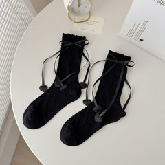 Black diamond knit crew socks with scalloped tops, ribbon bows and heart-shaped ribbon ends.