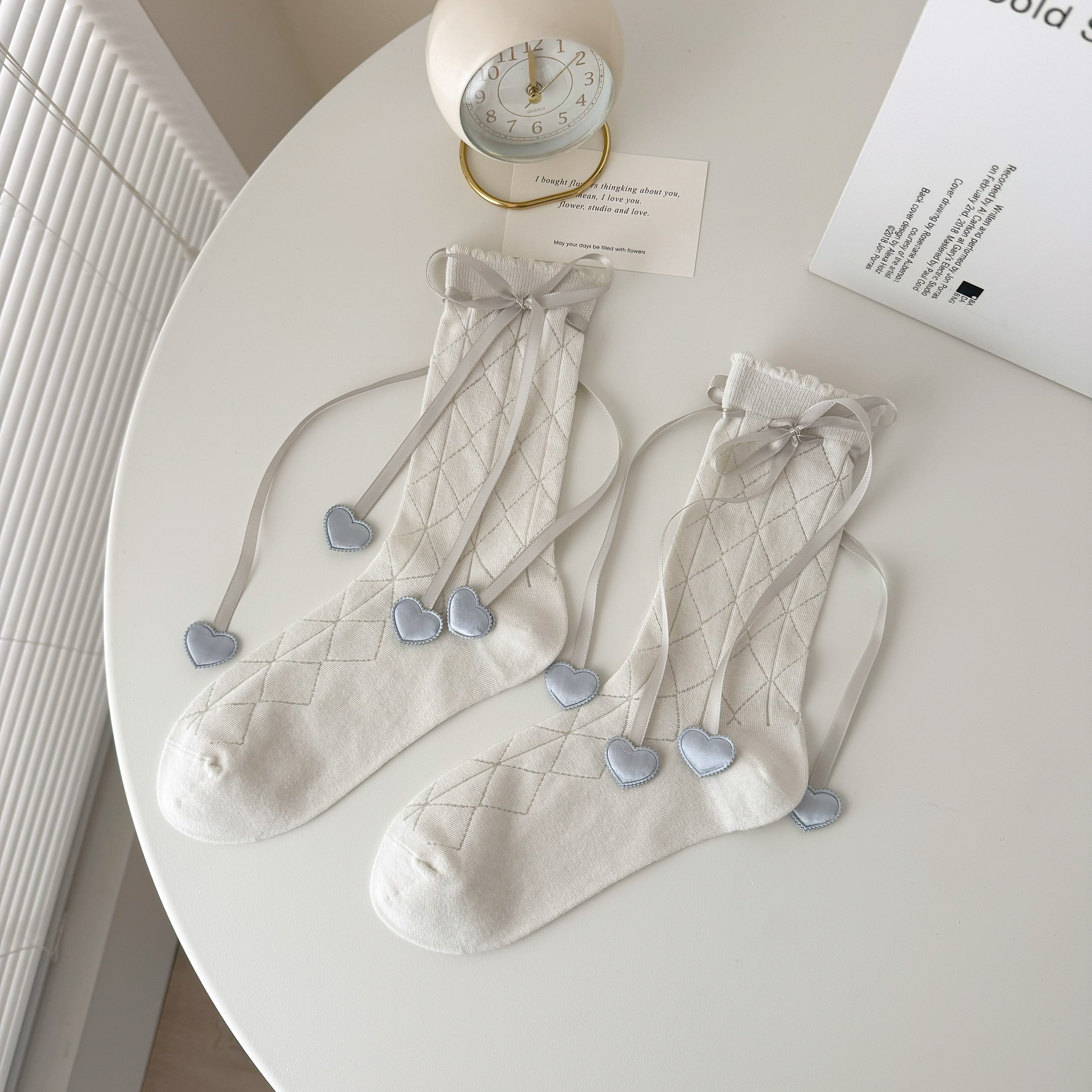 Gray diamond knit crew socks with scalloped tops, ribbon bows and heart-shaped ribbon ends.
