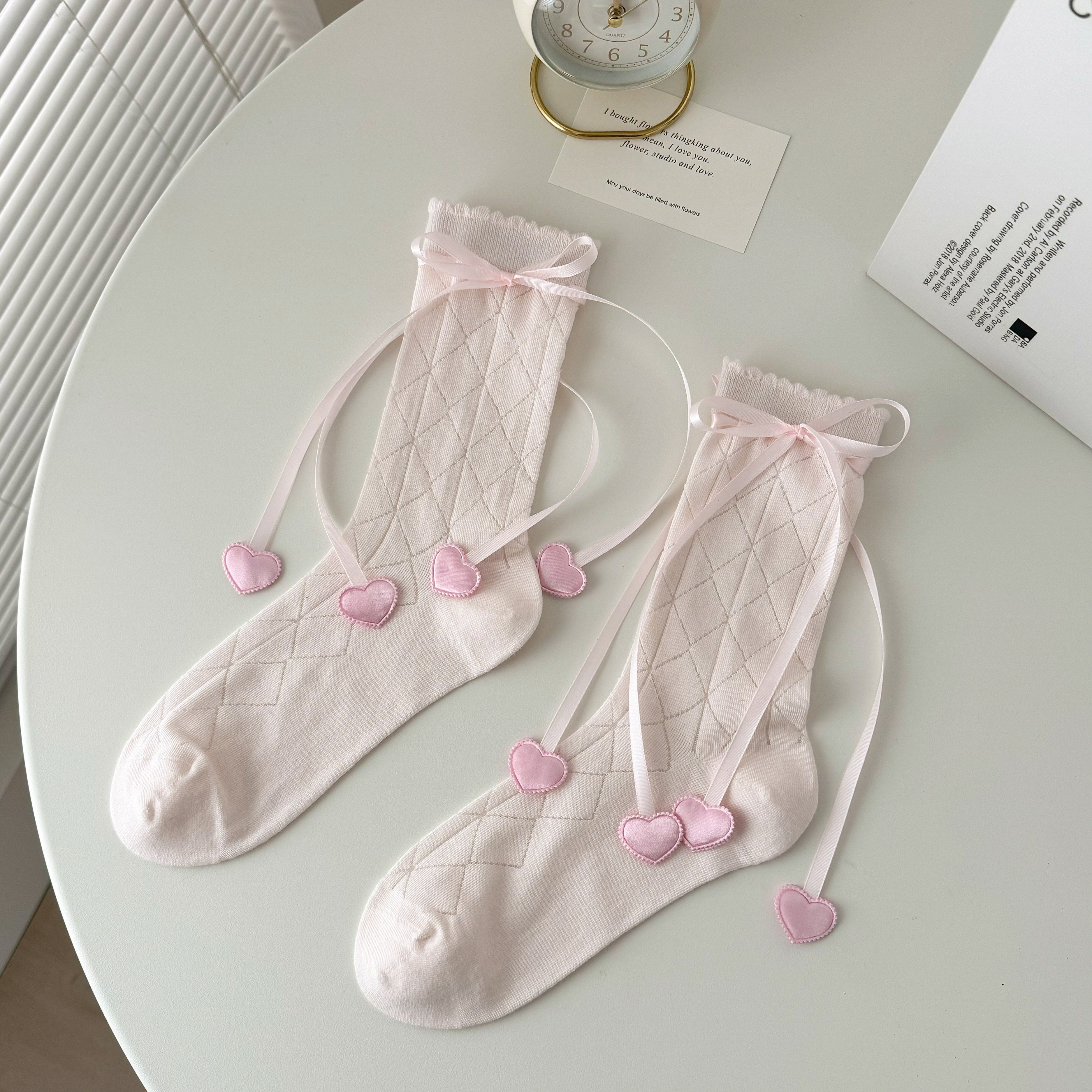 Pink diamond knit crew socks with scalloped tops, ribbon bows and heart-shaped ribbon ends.