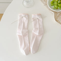Pink floral crew socks with tonal flower outlines and dotted ribbon cuff bows