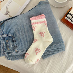 Cream sock body with pink bow motifs and two rows of pink raised cuff trim
