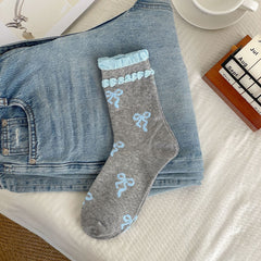 Gray sock body with light blue bow motifs and two rows of light blue raised cuff trim