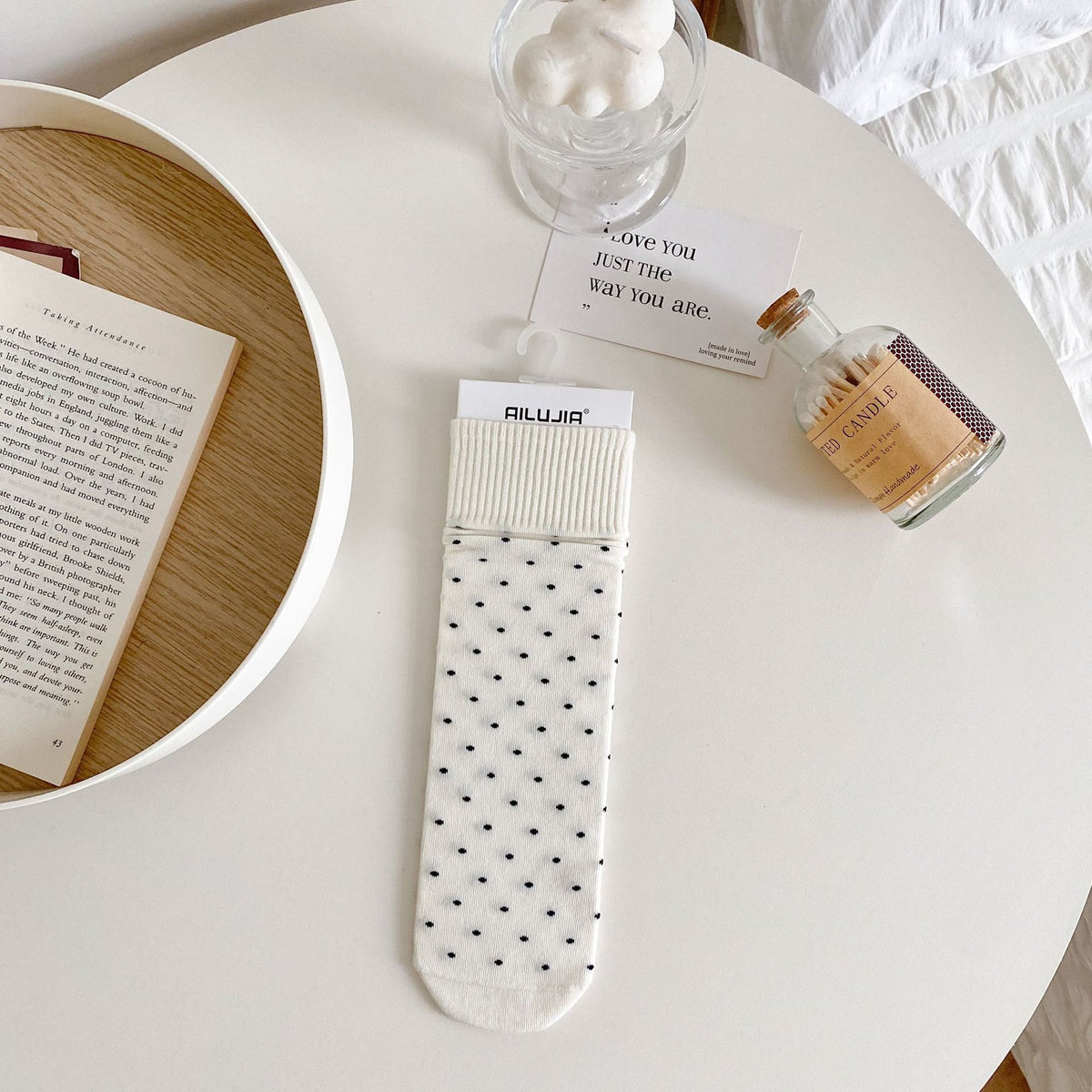 Milk White polka dot sock with dark dots and a broad ribbed cuff, laid flat