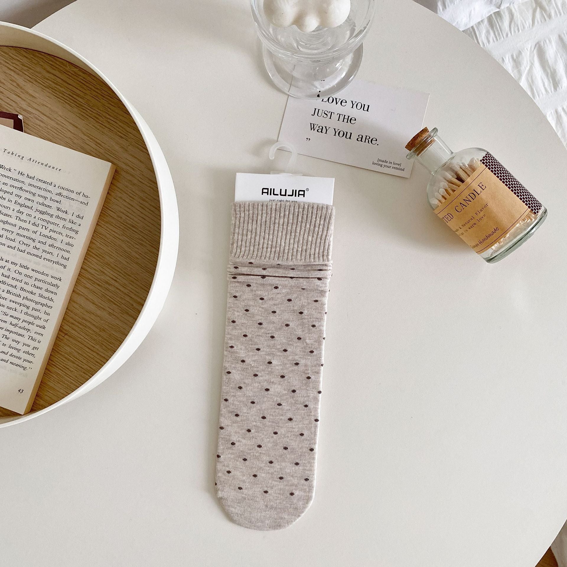 Oatmeal polka dot sock with dark dots and a broad ribbed cuff, laid flat