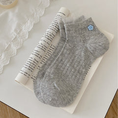 Gray ankle socks with vertical knit motifs, blue flower-button detail and fine mesh frills