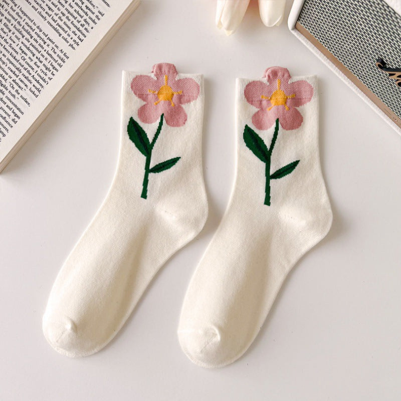 White crew socks with pink open flowers forming the cuff edges and green leafy stems