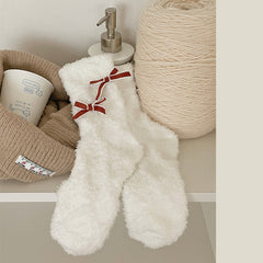 White fuzzy-looking crew socks with red bows outlined in pale trim